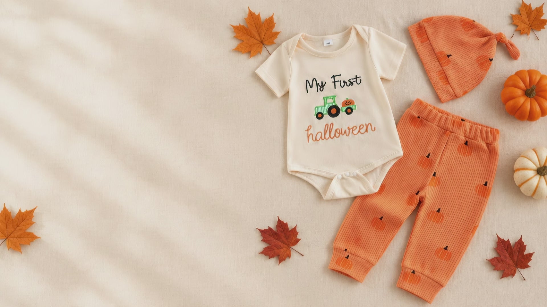 My First Halloween outfit flat lay with autumn leaves